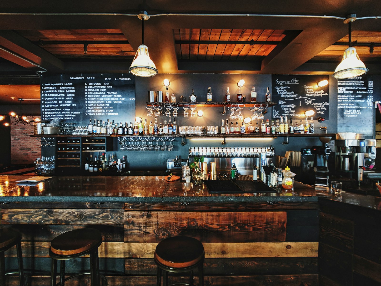 Interior de bar con luz cálida y estantería de botellas.